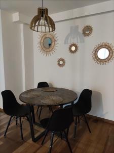 einen Esstisch mit Stühlen und Spiegeln an der Wand in der Unterkunft Apartament Andrea in Klein Öls