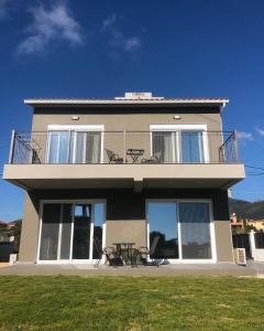 une maison avec un balcon, une table et des chaises dans l'établissement Taras Residence, à Karavádhos