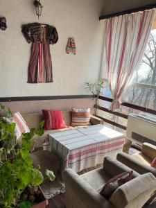 ein Wohnzimmer mit einem Sofa und einem Bett in der Unterkunft Хижа Тополица -The beautiful view in Aytos