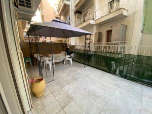 a patio with a table and an umbrella on a balcony at Danka Apartment in Thessaloniki