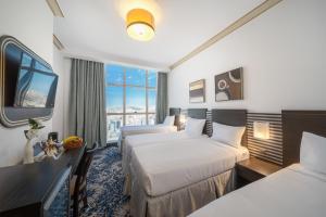 um quarto de hotel com duas camas e uma televisão em Al Kiswah Towers Hotel em Meca