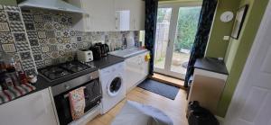 a kitchen with a stove and a washing machine at Stunning 1-Bed Studio in Windsor in Windsor