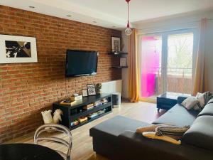 a living room with a couch and a brick wall at Dyrekcyjna Apartment in Wrocław