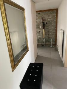 Habitación con espejo y banco negro en Chez Rémy, en Yverdon-les-Bains