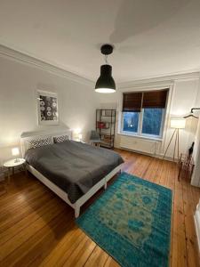 sypialnia z łóżkiem i dywanem oraz 2 oknami w obiekcie Sehr zentral / Hell / Altbau w mieście Hamburg