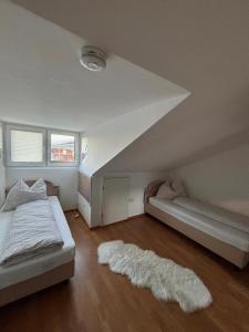 a bedroom with two beds and a white rug at RM-Apartments in Innsbruck