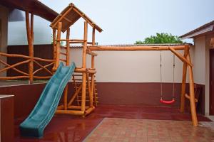 a playground with a slide and a swing at Tündérfátyol apartmanház in Poroszló