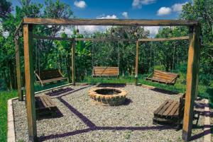 2 bancs et un foyer extérieur dans un parc dans l'établissement FINCA HOTEL LA BONITA BY LA MACORINA, à Quimbaya