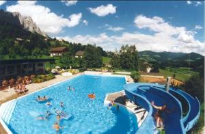 ein großes Schwimmbecken mit Menschen im Wasser in der Unterkunft Ferienhaus Walcher in Sankt Martin am Grimming