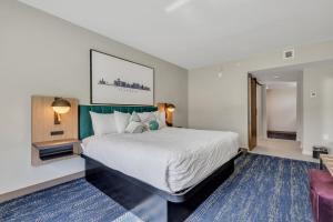 Un dormitorio con una gran cama blanca y una alfombra azul en The Kingston en Savannah