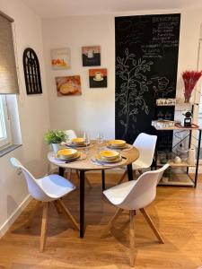 a dining room with a table and white chairs at Candelaria in Astorga