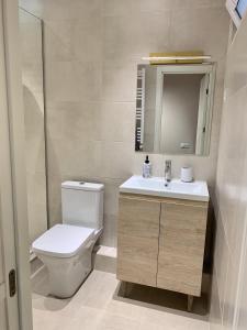 ein Badezimmer mit einem WC, einem Waschbecken und einem Spiegel in der Unterkunft Best Location Renovated Home in Tbilisi City