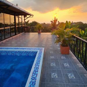 a swimming pool on the roof of a house with a sunset at Villa Susana in Filandia