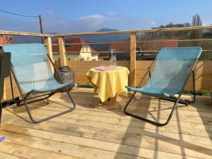 two blue chairs and a table on a deck at Au nid'Elma in Breitenau