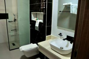 ein Bad mit einem Waschbecken, einem WC und einer Dusche in der Unterkunft Polo grand hotel in Maiduguri
