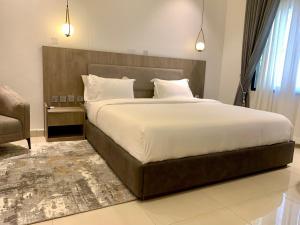 sypialnia z dużym łóżkiem z drewnianym zagłówkiem w obiekcie Polo grand hotel w mieście Maiduguri