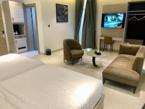sypialnia z łóżkiem, kanapą i telewizorem w obiekcie Polo grand hotel w mieście Maiduguri