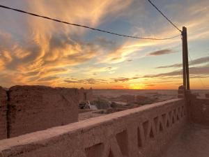 a sunset over the desert from a wall with a view at Authentic riad & activities Erg in Mhamid