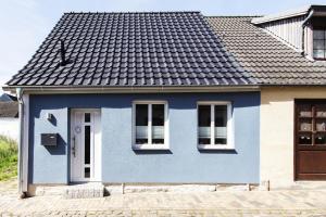 ein blaues Haus mit schwarzem Dach in der Unterkunft Hafensternchen in Husum