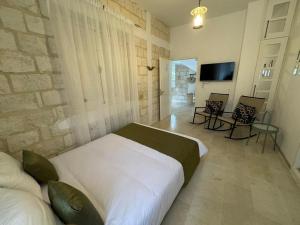 a bedroom with a large bed and a tv in it at Dar Daniella - Small Design Luxury Hotel in Tabarka