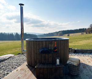 a wooden hot tub sitting on a wooden deck at Farma Náhlov in Frymburk