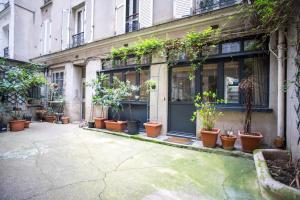 Ein Haufen Topfpflanzen vor einem Gebäude in der Unterkunft Loft branché dans le quartier le plus tendance de Paris in Paris