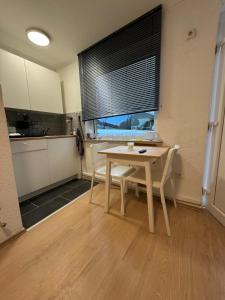 a room with a table and a kitchen with a window at Main Appartement in Flörsheim