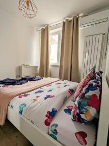 a bedroom with a bed with floral sheets and a window at Old town apartment in Bucharest