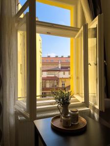 un vase avec des fleurs sur une table devant une fenêtre dans l'établissement Historical Heart Home, à Prague