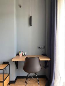 einen Schreibtisch in einem Zimmer mit einem Stuhl neben einem Fenster in der Unterkunft Cozy retreat close to mountains in Tbilisi City