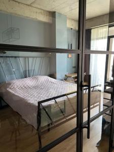 Bett in einem Zimmer mit einem Glasfenster in der Unterkunft Cozy retreat close to mountains in Tbilisi City