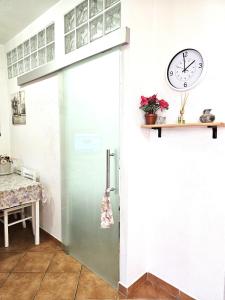 a sliding door in a kitchen with a clock on the wall at MARINA OF OLBIA APARTMENT iun r3714 in Olbia