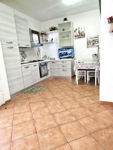 a kitchen with white cabinets and a dining table at MARINA OF OLBIA APARTMENT iun r3714 in Olbia