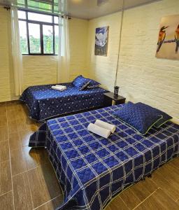 duas camas com lençóis azuis num quarto em Villa Susana em Filandia