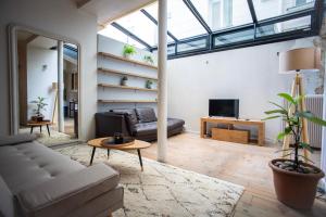 ein Wohnzimmer mit einem Sofa und einem Tisch in der Unterkunft Loft branché dans le quartier le plus tendance de Paris in Paris
