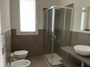 a bathroom with a shower and a toilet and a sink at Polinesia 12 in Lido delle Nazioni