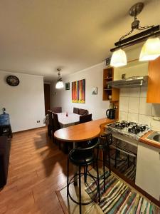 eine Küche und ein Esszimmer mit einem Tisch und einem Herd in der Unterkunft Apartamento Full Equipado Santiago Centro in Santiago
