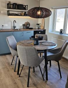 a dining room table with chairs and a kitchen at Kviholmi Premium Apartments in Hvolsvöllur