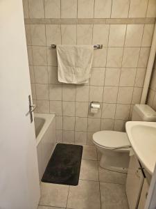 a bathroom with a white toilet and a sink at Joli Studio in La Chaux-de-Fonds