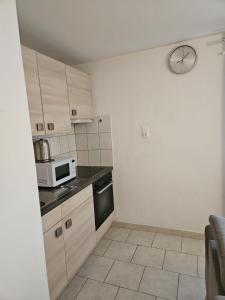 a small kitchen with a clock on the wall at Joli Studio in La Chaux-de-Fonds +7 photos