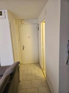 a hallway with a door and a tile floor at Joli Studio in La Chaux-de-Fonds