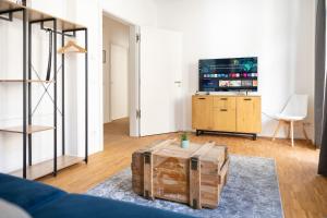 a living room with a table and a tv at Ko-Living - Gaming Suite am Alten Markt - Altstadt - 6P in Halle an der Saale