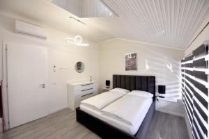 um quarto com uma cama e uma parede branca em Vila Hope 5 em Tirana