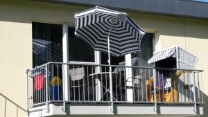 - un balcon avec deux parasols sur une fenêtre dans l'établissement Ferienwohnung OG Kasten GM 69471, à Müritz