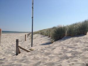 een strand met een hek en een paal in het zand bij der Strandkater OG DG Priemer GM 69667 in Müritz