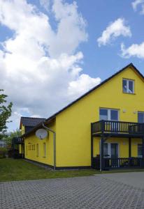 a yellow building with a clock on the side of it at Ferienwohnung 7 Kern Wolke 7 - GM 69469 in Graal-Müritz