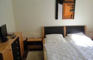 a bedroom with a bed and a desk with a television at Bucheneck WE 13 Simon GM 69758 in Graal-Müritz
