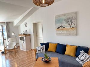 een woonkamer met een blauwe bank en een tafel bij Fewo Ankerkette - Villa Victoria in Graal