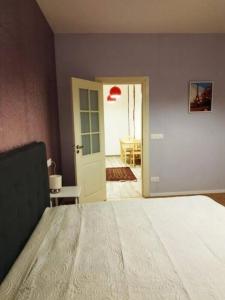 1 dormitorio con 1 cama y puerta a una habitación en GERS -Midi-Pyrénées -Appartement 2chambres, en Castelnau-dʼAuzan