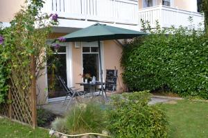 a table and chairs under an umbrella in a yard at Fewo Möwenweg 8 - Damme GM 69180 in Graal-Müritz +27 photos
